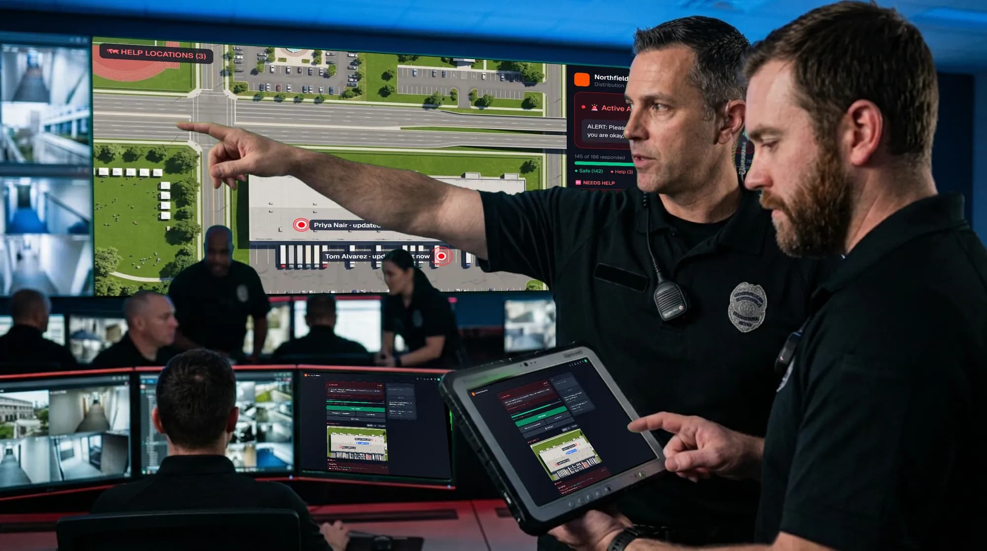 Two security officers at a video wall showing SafeAlert’s satellite HELP map, one holding a tablet.